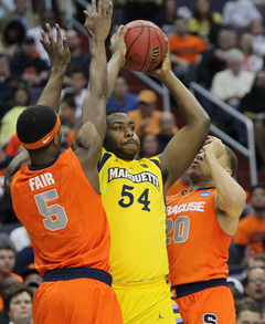 Davante Garner #54 of the Marquette Golden Eagles attempts to pass the ball against C.J. Fair #5 and Brandon Triche #20.