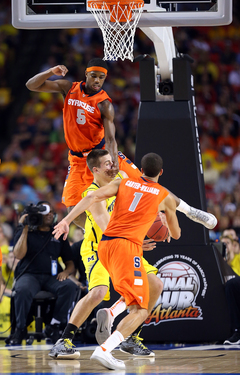 C.J. Fair #5 of the Syracuse Orange and teamate Michael Carter-Williams #1 block Mitch McGary #4 of the Michigan Wolverines.