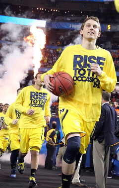 Nik Stauskas and the Michigan Wolverines run onto the court.