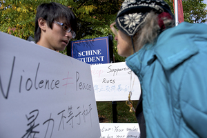 Yuming huang, a senior international relations, public relations and economics triple major, speaks to Lenora Monkemeyer, a Syracuse alumna, during a protest against the Dalai Lama. Some SU students, like Huang, believe the Dalai Lama creates conflict instead of peace