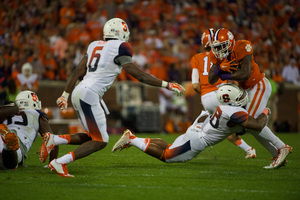 Cameron Lynch (right) wraps up a ball carrier in Syracuse's loss to Clemson at Memorial Stadium on Saturday night. 