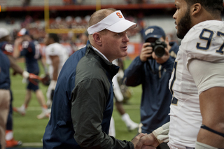 Orange head coach Scott Shafer congratulates Pitt defensive tackle Aaron Donald, who blocked an extra point.