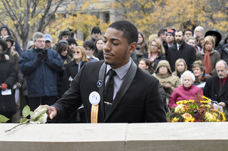 SU Remembrance Scholar Malik Evans places a rose.  
