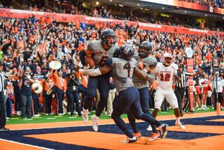 Williams celebrates with teammates after saving a touchdown.