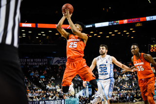 Battle floats a runner in the lane with Tar Heels defender Luke Maye looming. 
