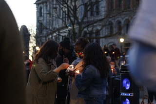 Women’s March Syracuse Organizer Nada Odeh uses her candle to light more candles at the vigil.