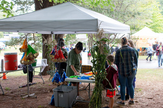 Families go to collect the ribbons they earned for playing the games at the festival. Each color ribbon corresponds to a different age group and visitors can get the respect one at the table when they leave the game area. 